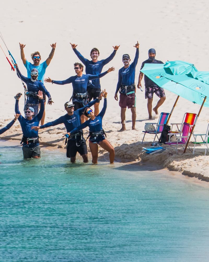 L'équipe de la Nossa Vibe réunie au bord de l'eau, les dunes en arrière-plan, à Atins